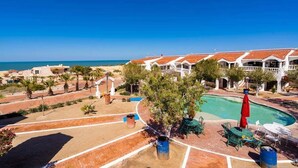 A resort with a pool, outdoor seating, and a view of the sea. - La hacienda condo Four (San Felípe)