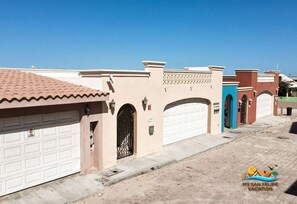 A residential street with houses featuring arched garage doors and decorative elements. - Las Palmas condo One (San Felipe)