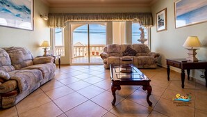 A spacious living room with a sofa, a coffee table, and a lamp. - Jerry`s Beach Club Condo 2 (San Felipe)