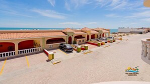 A beachside hotel with multiple rooms, a parking area, and a view of the ocean. - Jerry`s Beach Club Condo 2 (San Felipe)