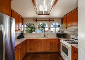 Kitchen features a central island, stainless steel appliances, and tile flooring.