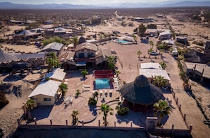 An aerial view of a resort with a swimming pool, palm trees, and a thatched-roof structure. - 1-Bedroom Beach Studio  - Serene getaways. (San Felipe)