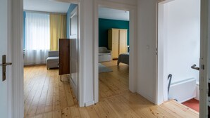 A spacious room with wooden flooring, a bed, a wardrobe, and a radiator. - Familienfreundlich - Farbenfroh - Außergewöhnlich (Braunlage)