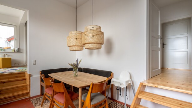 A dining area with a wooden table and chairs, a woven pendant light, and a rug. - Familienfreundlich - Farbenfroh - Außergewöhnlich (Braunlage)