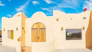 Un bâtiment doté d’une façade incurvée, d’une porte en bois, d’une fenêtre et d’un petit balcon.