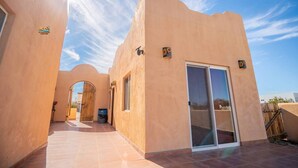 Un bâtiment doté d’une façade incurvée, d’une grande porte-fenêtre coulissante et d’un petit espace patio.