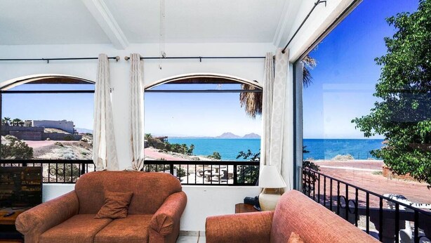 Une chambre avec balcon, un canapé et vue sur la mer.