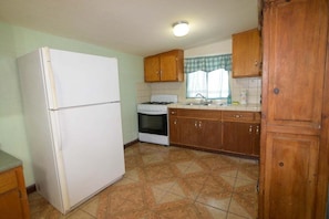 A kitchen with a refrigerator, stove, sink, and wooden cabinets. - Casa Bell Tower -bedroom rental home (San Felípe)