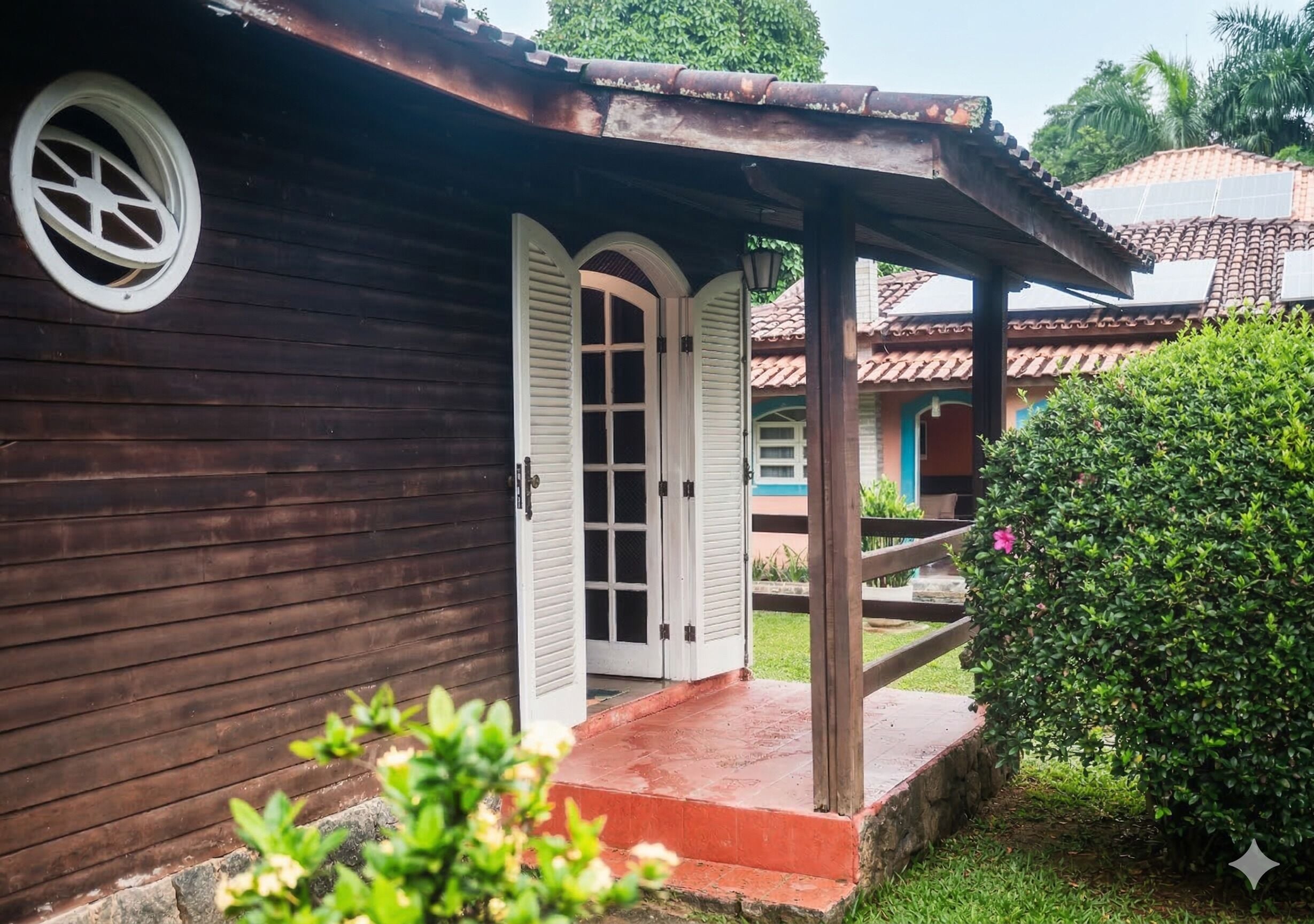 A wooden building with a porch, a door, and a small window.
