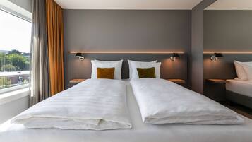 Une chambre d’hôtel moderne avec un grand lit, deux tables de chevet et une vue sur la ville.