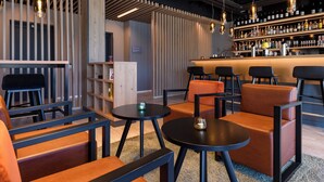 A modern bar area with seating and a bar counter. - Piazza Hotel und Restaurant (Aalen)