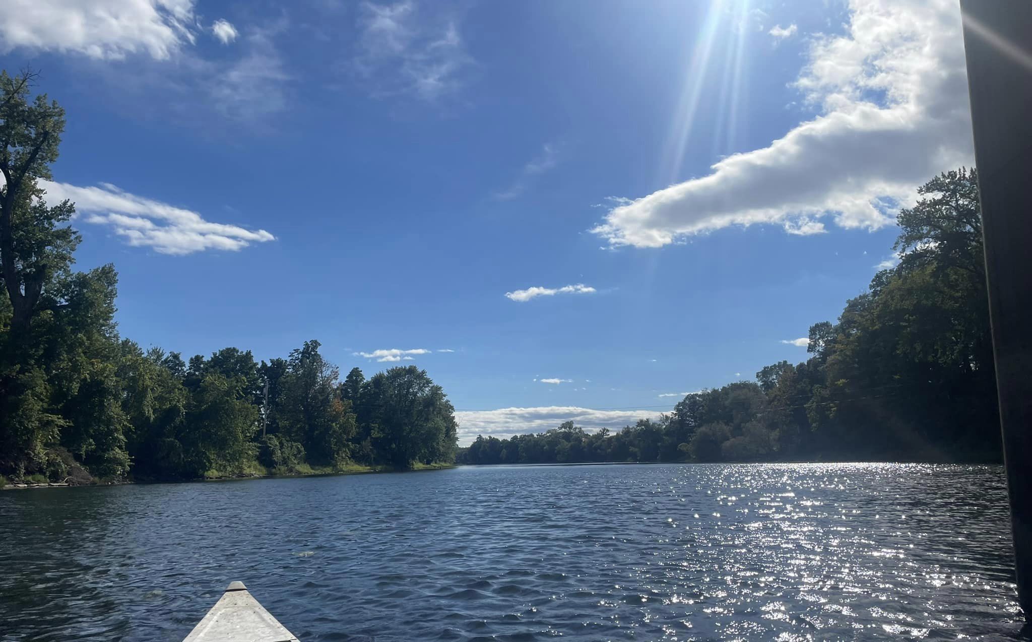 Un lac paisible, avec un ciel dégagé et des arbres qui bordent ses rives.