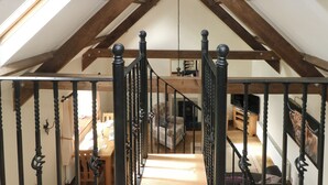 A staircase with a wooden interior and a black metal railing. - The Old Dairy (Clarbeston Road)
