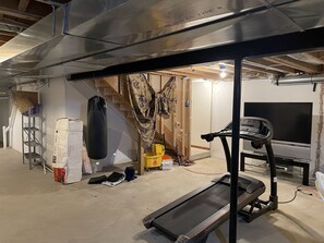 Work out and unwind in this fitness space with a treadmill, punching bag, and TV.