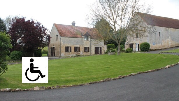 A building with a paved driveway and a grassy lawn.
