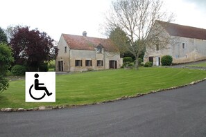 A building with a paved driveway and a grassy lawn.
