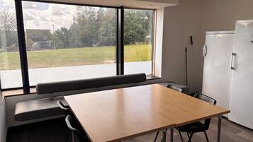 Una cocina moderna con un ventanal grande, una mesa de madera y un banco empotrado.