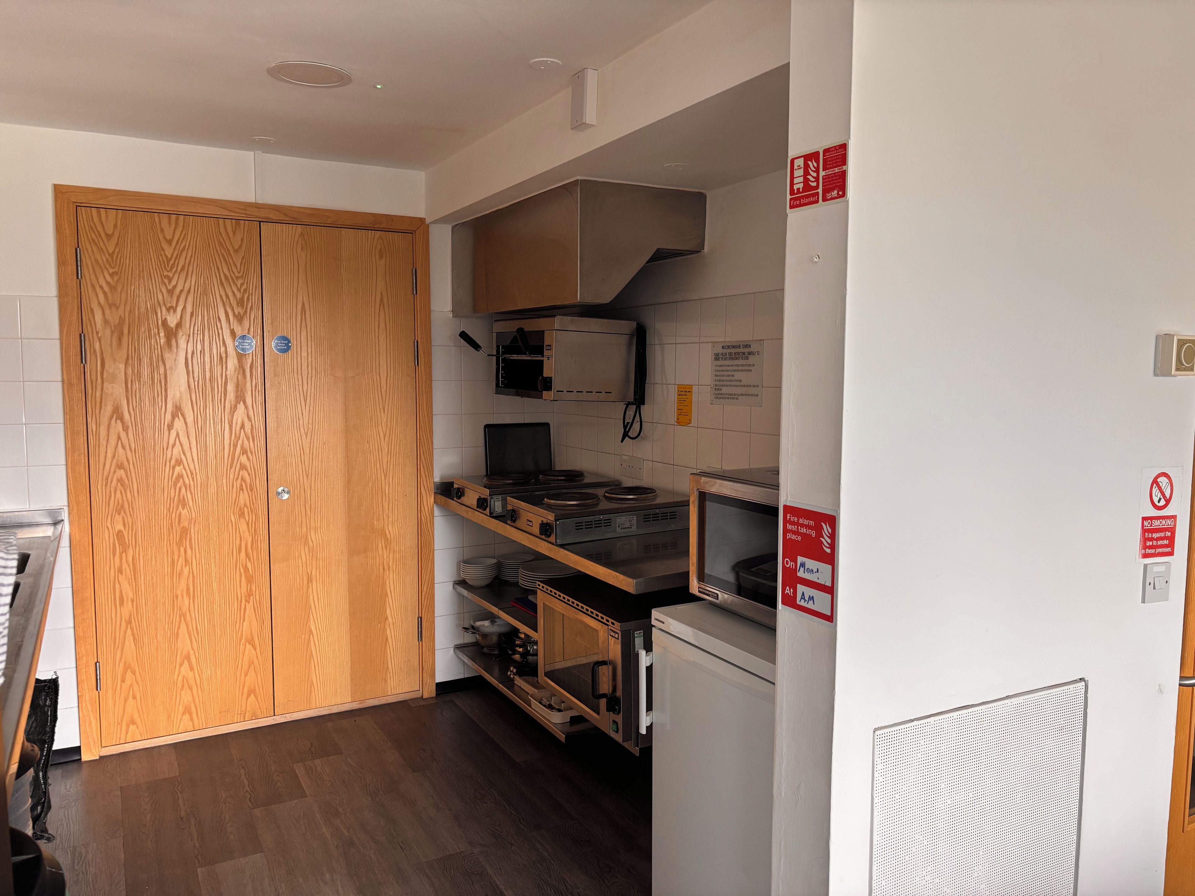 Une cuisine compacte équipée d’un four à micro-ondes, d’une cuisinière et d’un réfrigérateur.