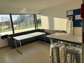 Una habitación moderna con un amplio ventanal, un sofá, una mesita y una zona de bar.