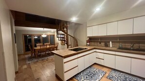 Una cucina moderna con isola centrale, pavimento in legno e piano cottura integrato.