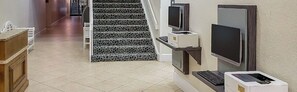 Staircase and reception area with a flat-screen TV and patterned tile design.