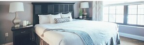 Cozy retreat with a large bed, two nightstands, and a potted plant.