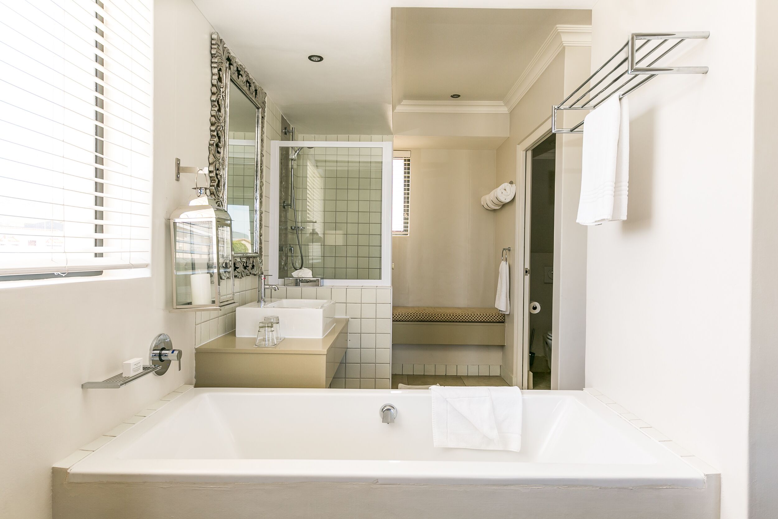 A modern bathroom with a large bathtub, a sink, and a shower area.