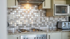 Una cocina con estufa de acero inoxidable, microondas y tostadora.