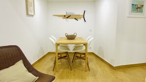 A dining area with a wooden table, white chairs, and a wicker chair.