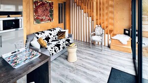 Un intérieur moderne avec un espace de vie aménagé dans le style d’un loft, une table à manger et une cuisine.