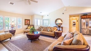 A spacious living room with a large sofa, a coffee table, and a ceiling fan. - Key Colony Beach Paradise (Key Colony Beach)