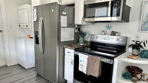 Une cuisine moderne dotée d’appareils électroménagers en acier inoxydable, d’un plan de travail en bois et d’un four encastré.