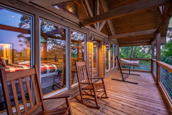 Relax on the deck with a rocking chair and hammock, surrounded by trees and scenic views.