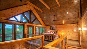 Uma cabana com quarto no mezanino, área de refeições e vista para o exterior.
