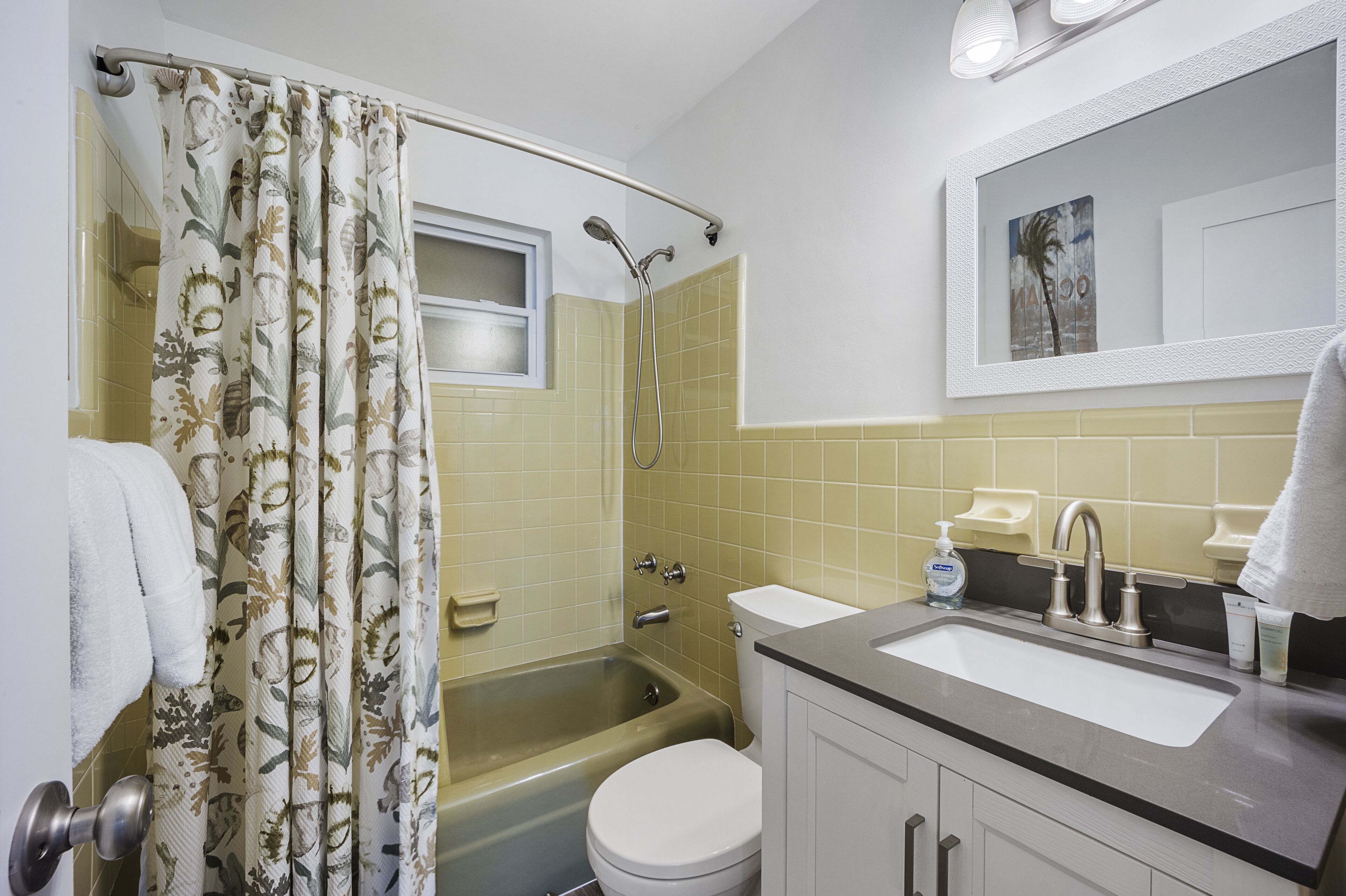 A bathroom with a bathtub, toilet, sink, and a shower curtain.