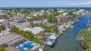 A coastal residential area with houses, a marina, and a swimming pool. - Waterfront Oasis w/ Pool, Tiki Lounge, Dock & BBQ (Marathon)