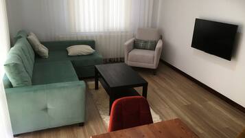 Comfort Condo, Balcony | Living area | 70-cm LCD TV with satellite channels
