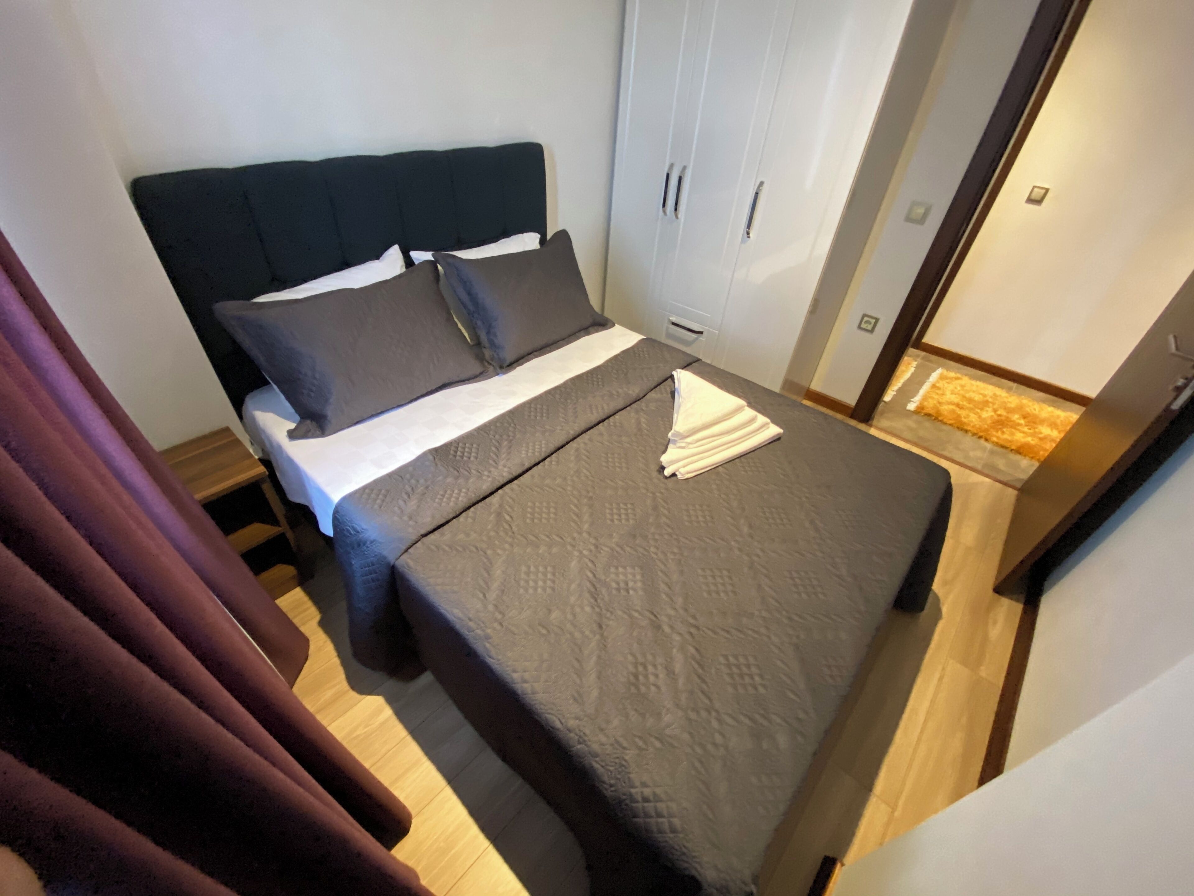 Un dormitorio con cama, armario y baño.