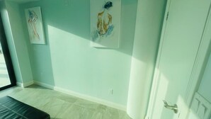 Ein Zimmer mit einem Bett, zwei Bildern an der Wand und einer Tür.