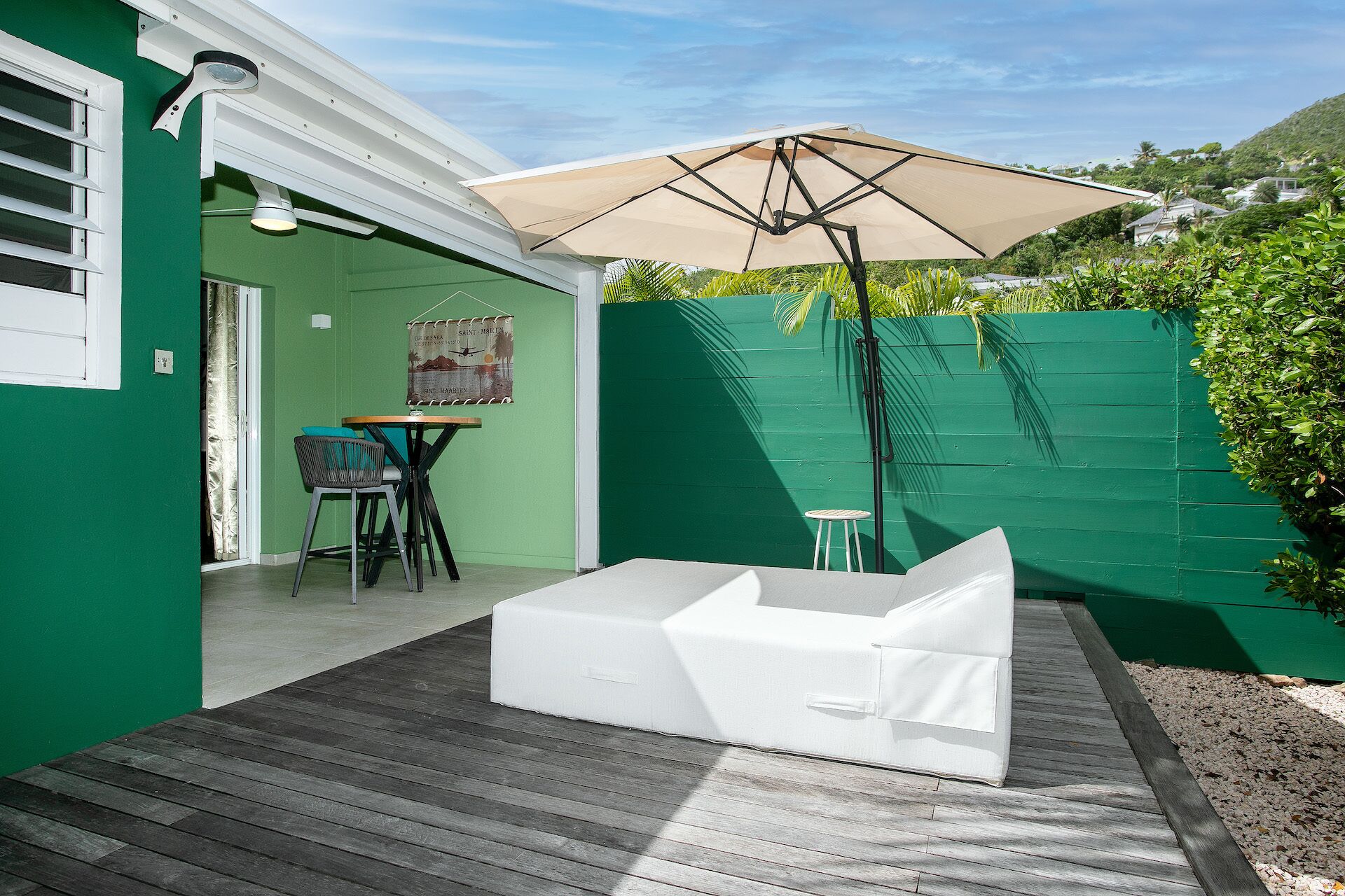 A patio with a white sofa, a table, and chairs.