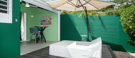 A patio with a white sofa, a table, and chairs.