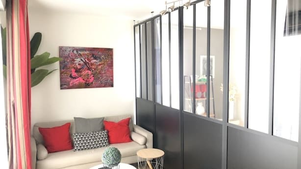 Un salon avec un canapé, une table basse et une plante décorative.