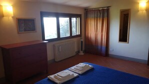 A bedroom with a bed, a dresser, a radiator, a window, and a curtain. - Il ponticello Cortona, delightful little house in the green with breathtaking views (Cortona)