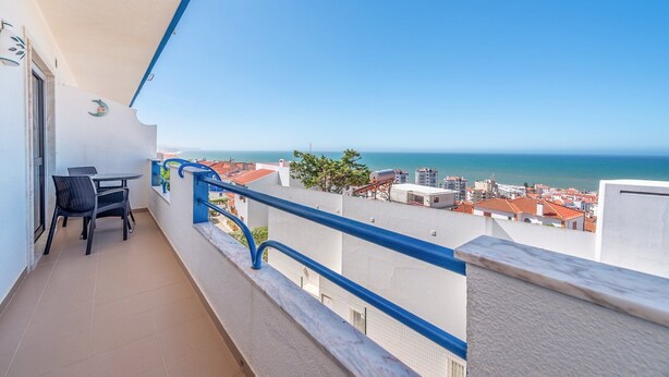Un balcon avec vue sur la mer et les bâtiments.