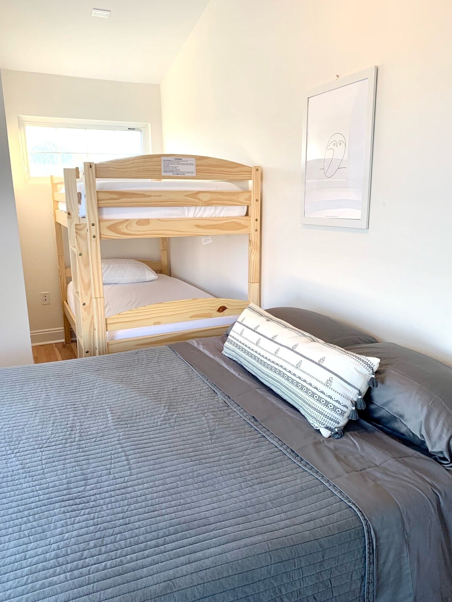 Una cama litera con un colchón acolchado gris y una almohada decorativa.