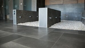 A modern lobby with a tiled floor, a white column, and a pebble bed.