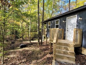 A cabin with a wooden deck and a door.
