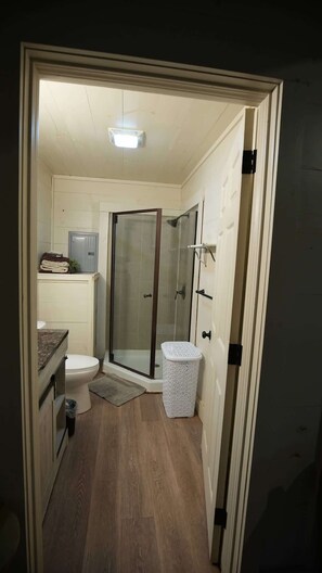 Ein kleines Badezimmer mit Toilette, Dusche und einer kompakten Spüle.