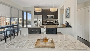 A modern kitchen with dark cabinets, stainless steel appliances, and pendant lighting. - "Bliss of Evanston" 180°view, 2BDR +2Bath UrbanLux (Evanston)