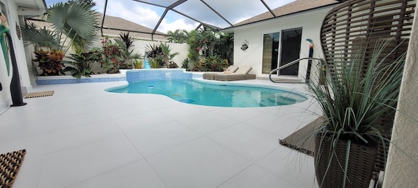 Relax by the pool surrounded by lush greenery and lounge chairs.